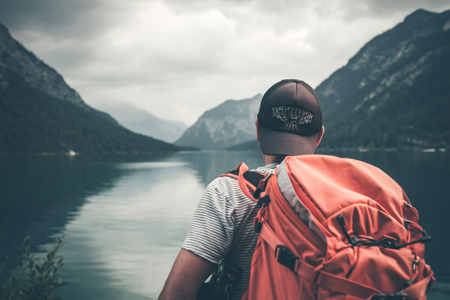 Talha face à un lac de montagne, sac sur le dos